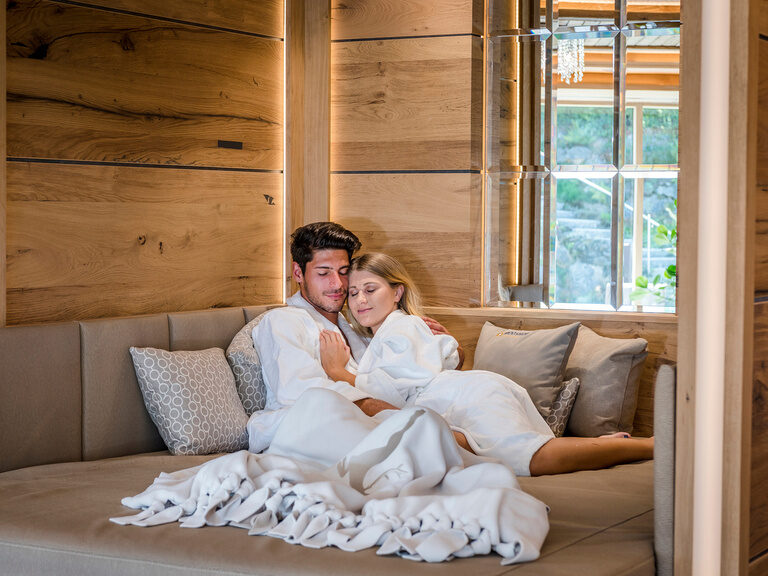Ein Paar genießt seine Freizeit auf einer komfortablen Couch in einem der luxuriösen Ruheräume des Hotels Mooshof in Bodenmais.